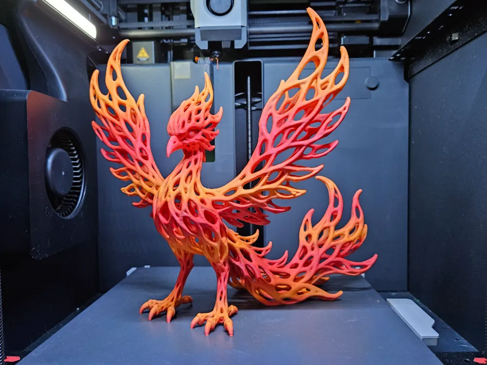 Fênix impressa em 3D com padrão vazado em degradê laranja e vermelho