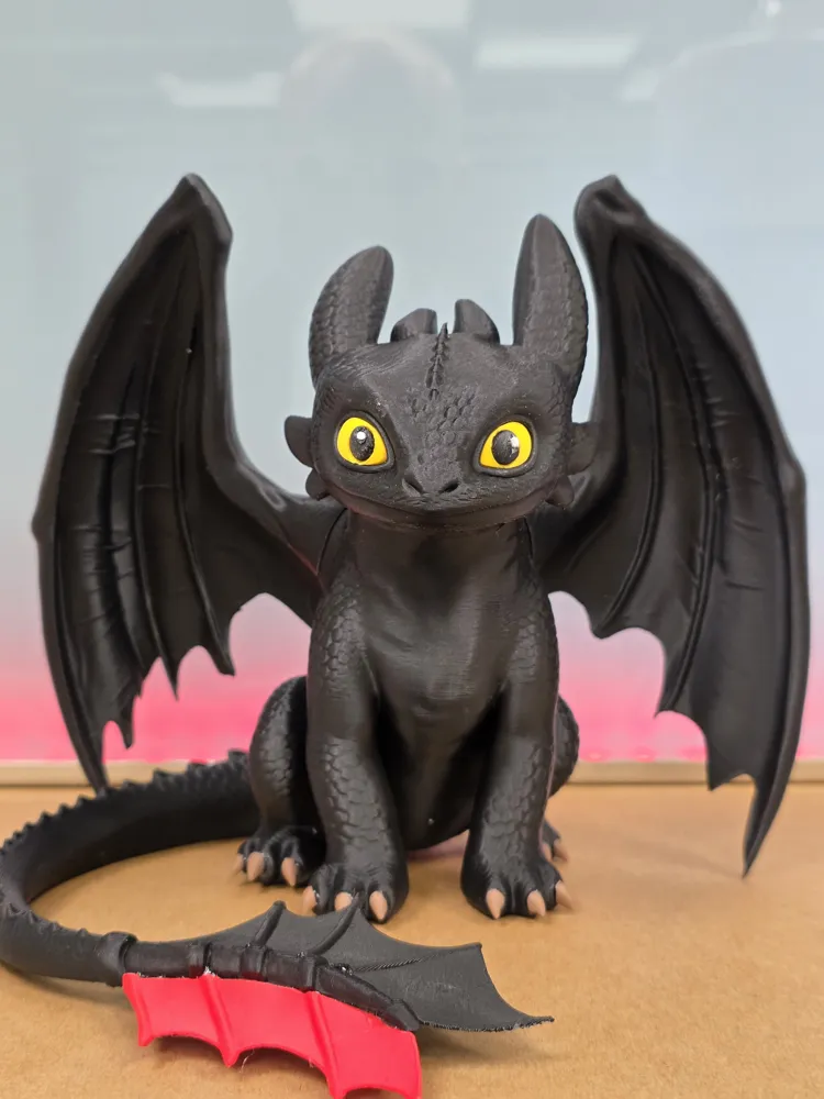 Dragão preto impresso em 3D com olhos amarelos e asas abertas
